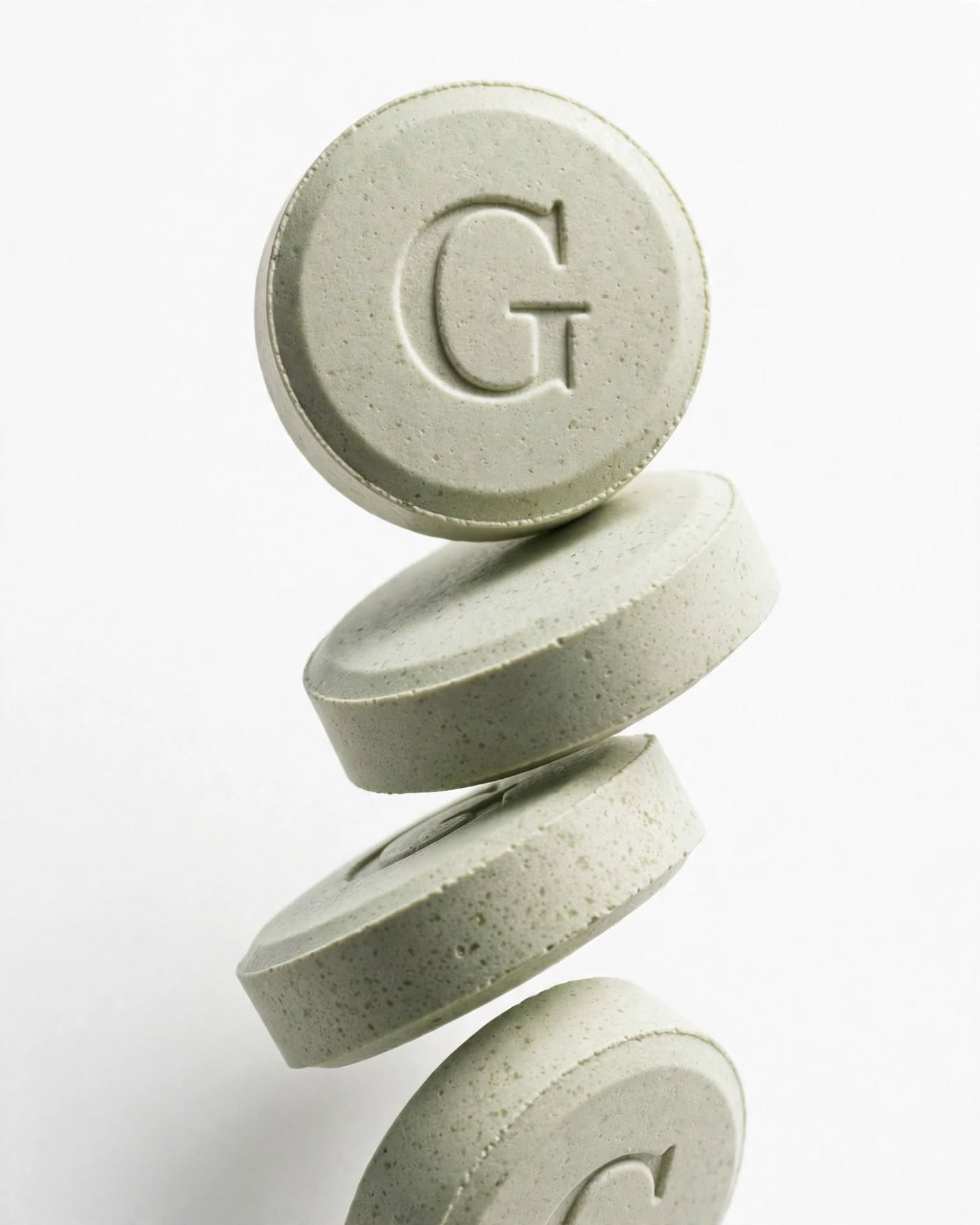 Stack of embossed mint-green Dose of Better wellness tablets
